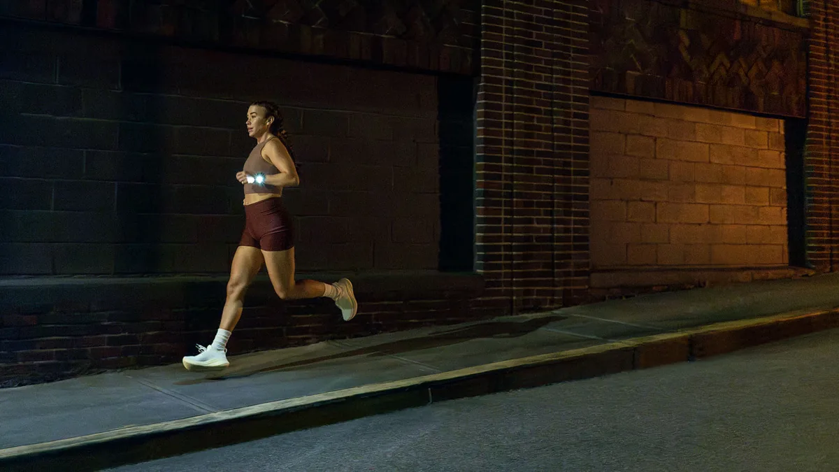 Coureuse de nuit en ville avec une Garmin Forerunner 970